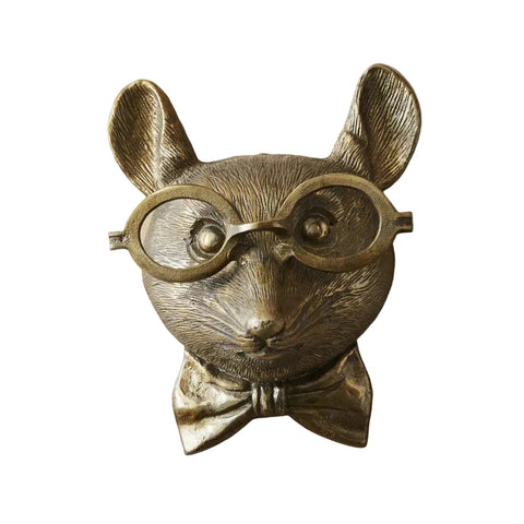 Bronze mouse figurine with glasses and a bow tie on a light pink background