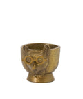 Bronze-colored egg cup with a face design on a white background