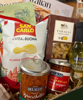Assorted Italian food products including chips, olives, and tomato bruschetta in a box.