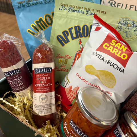 Assorted food products including salami, hot sauce, and potato chips in a box.