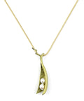Gold necklace with a pea pod pendant featuring two pearls