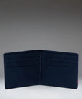 A dark navy blue bifold wallet shown open against a gradient gray studio background.